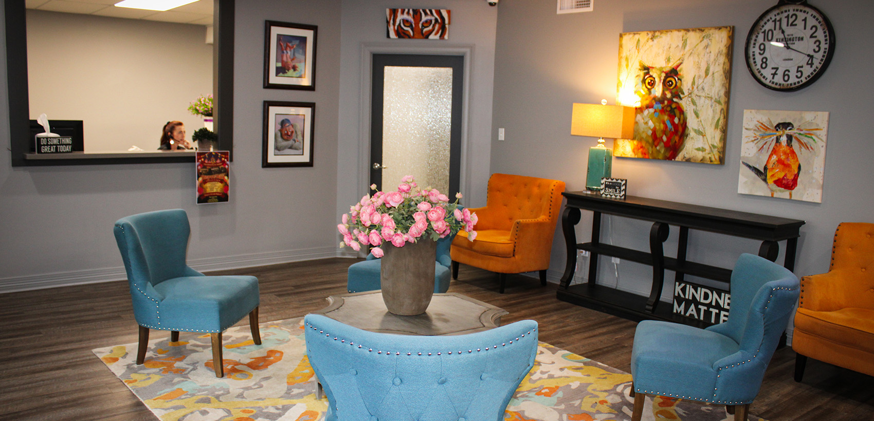 The waiting room at Green & Dileo Dentistry with turquoise and orange comfortable chairs